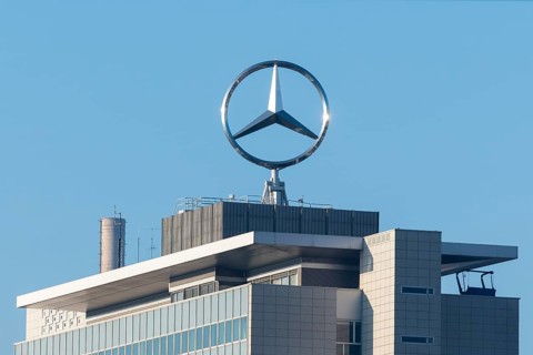 Close-up of a roof with emblazoned Mercedes logo and chimney surrounded by blue sky, Mercedes star,
