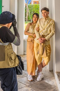 Young woman and young man in traditional clothing present themselves for the photographers, Wat