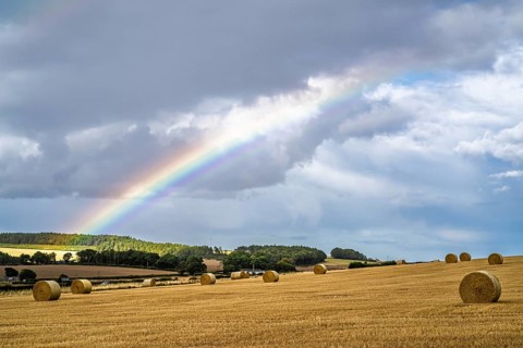 Rainbow over Straw bales, Scottish fields, Southeast Scotland, UK