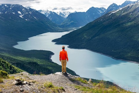 Mountaineer enjoys views of blue lake and mountains on Twin Peaks Trail, Eklutna Lake, Chugach