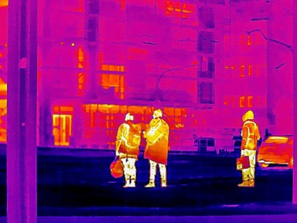 Thermal image or thermography, symbolic photo, interpolated. People traveling in urban areas.