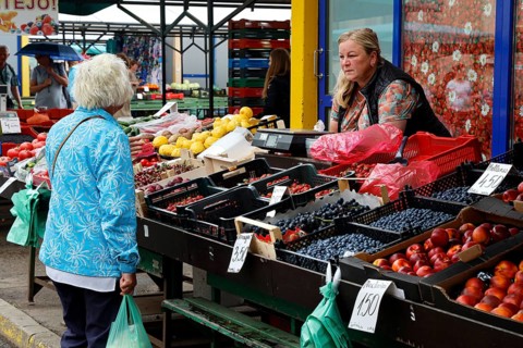 Saleswoman presents fruit and vegetables at the Central Market in Riga, Riga, Central Market,