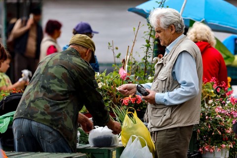 Men buy flowers at the busy Central Market in Riga, Riga, Central Market, Latvia