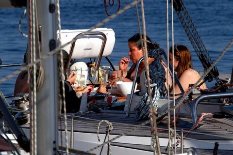 Group of people relaxing on a sailboat in harbour, Smögen, Västra Götaland, Sweden