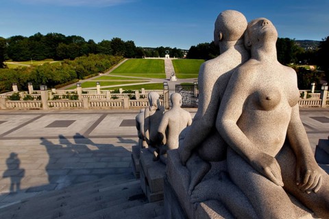 Group of granite figures in sunlight with view of parkland, Oslo, Norway