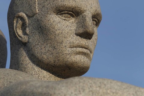 Detail of a granite sculpture in Vigelandsparken shows concentrated face, Oslo, Norway