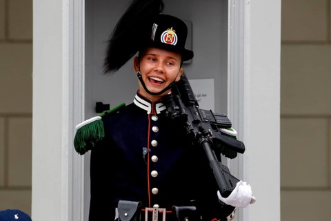 Smiling security guard in full uniform outside the Royal Palace in Oslo, Norway