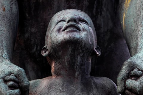Detail of a bronze sculpture in Vigelandsparken shows a child's face with expressive facial