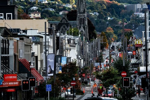 Lively shopping street with historic buildings and hills in the background in Dunedin, Dunedin,