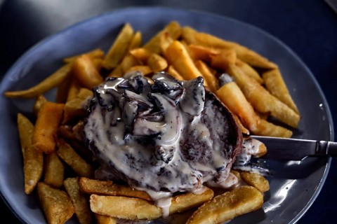 Steak with rich sauce on fries at Havelock Hotel, Havelock, Marlborough, New Zealand