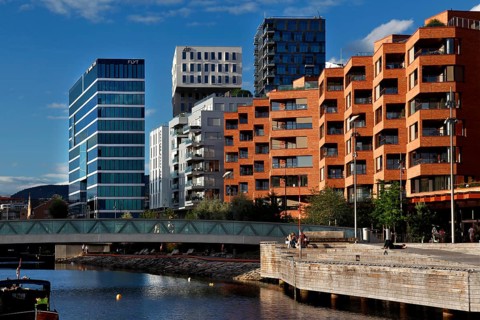 Colourful modern facades along the water in bright blue sky, Oslo, Norway