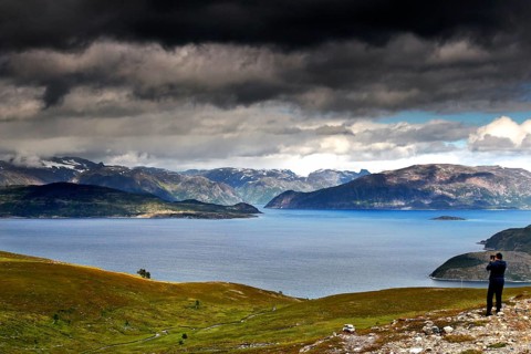 View of Lyngen Fjord with dramatic clouds and hikers, Lyngen Fjord, Troms, Norway
