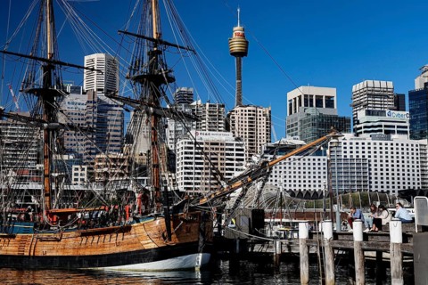 Historic sailing ship in Darling Harbour in front of a modern skyline under blue sky, Sydney, New