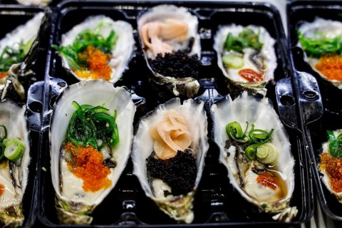 Decoratively presented oysters with green and black toppings at Sydney Fish Market, Sydney, New