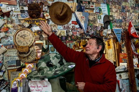 Person touches hat wall at Barrow Creek Hotel, Barrow Creek, Australia