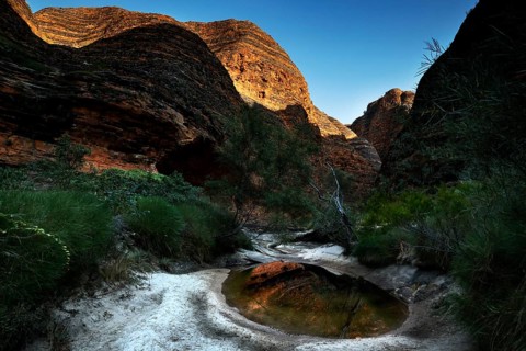 Circularly shaped rock formations and a small stretch of water in Cathedral Cove, Purnululu