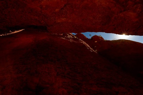 Light rays penetrate the tight, reddish brown Echidna Chasm, Purnululu, Western Australia,