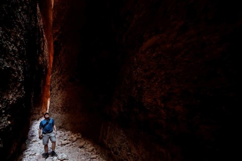 Hikers in the dark, impressive Echidna Chasm with narrow rock walls, Purnululu, Western Australia,