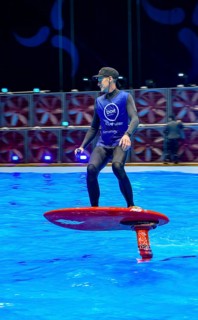 Press photo dynamic photo of eFoil surfer in the large XXL pool in Hall 17 of Messe Boot