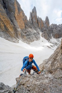 Mountaineer climbs on a steep rock face in the Via Ferrata dell'Ideale via ferrata, spectacular