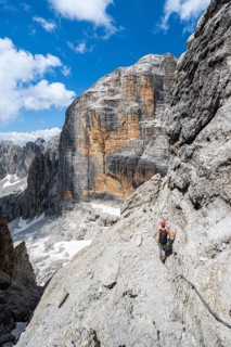 Climbers on the Via Ferrata Brentari via ferrata, spectacular mountain landscape with steep cliffs,