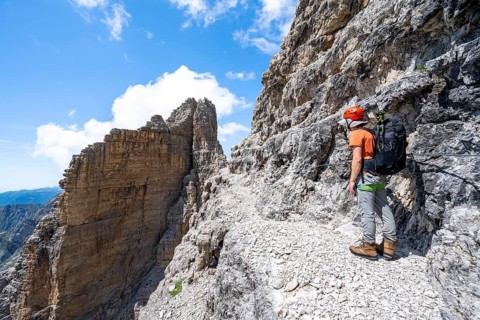 Climbers on the Via Ferrata Brentari via ferrata, spectacular mountain landscape with steep cliffs,