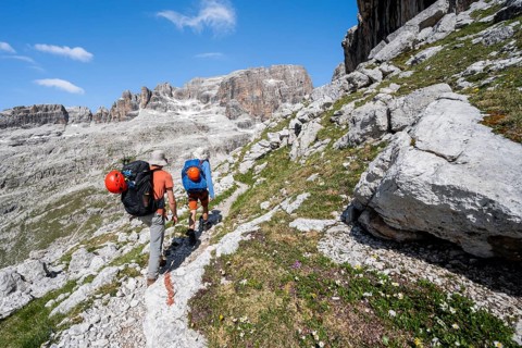 Two mountaineers on a hiking trail to Sella della Tosa, mountainous landscape in the Brenta