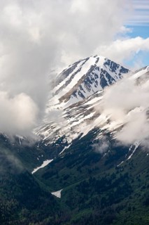 Fog sweeps around mountain peaks with remnants of snow, view from Slaughter Ridge Trail, Cooper