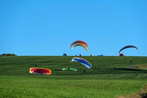 Paragliders practice on a meadow slope, Tauchersreuth, Middle Franconia, Bavaria, Germany
