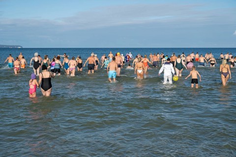 Swimmers run into water to bathe, tourist attraction Binzer Abbaden, Binz, seaside resort, Rügen