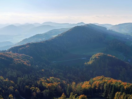 View of an autumnal forest from the Gisliflue, behind the Jurassic foothills with the Wasserfluh,