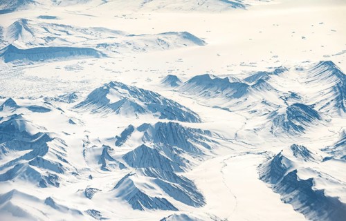 Icy, snowy arctic mountain landscape with glaciers, aerial view, Greenland, Arctic
