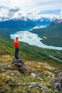 Climber enjoying the view, Slaughter Ridge Trail, view of snowy mountains and turquoise blue Kenai