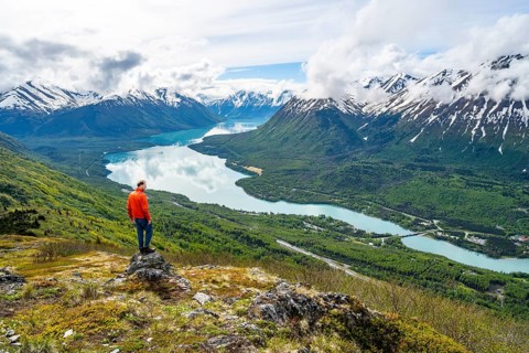 Climber enjoying the view, Slaughter Ridge Trail, view of snowy mountains and turquoise blue Kenai