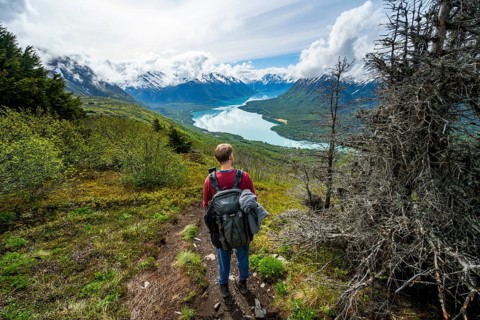 Climbers on a hiking trail, Slaughter Ridge Trail, view of snowy mountains and turquoise lake Kenai