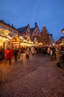 December 22, 2025, Frankfurt Christmas Market on Roemerberg at twilight. Traditional wooden stalls