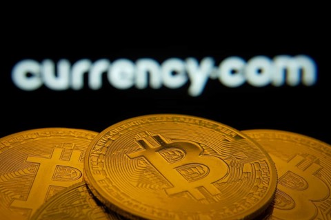 Dhaka, Bangladesh- 22 June 2025: Close-up of Bitcoin coins with the Currency.com logo visible on a