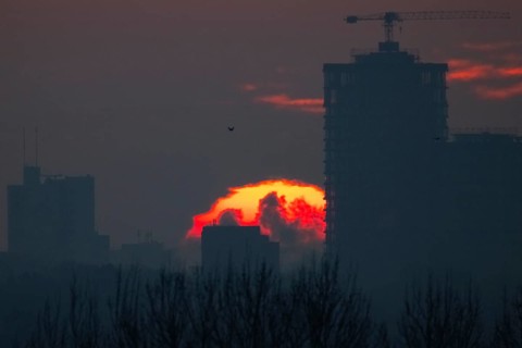 The sun rises behind Frankfurt's banking skyline, Frankfurt am Main, Hesse, Germany