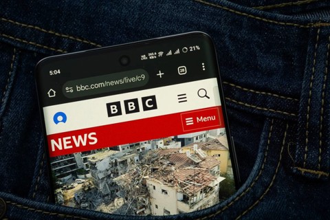 Dhaka, Bangladesh- 15 June 2025: A smartphone displaying the BBC web interface peeks out of a denim