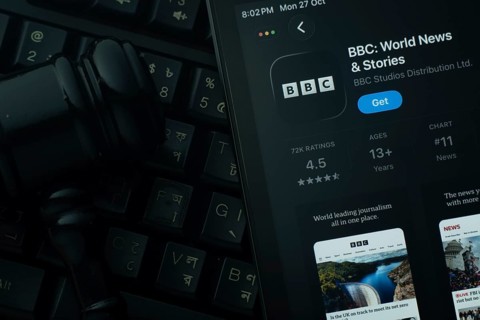Dhaka, Bangladesh- 28 Oct 2025: An iPad displaying the BBC app against a judge's gavel and dark