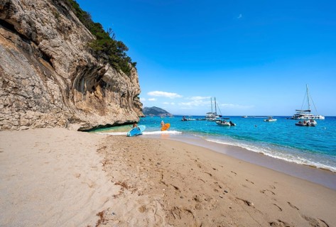 Sandy beach beach and steep cliffs at Cala Luna, Golfo di Orosei, Baunei, Sardinia, Italy