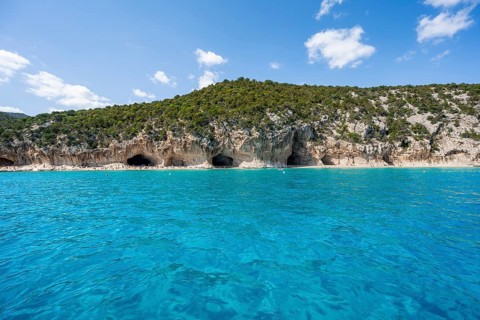 Clear blue water and picturesque rocky coast, Cala Luna cliffs and beach, Golfo di Orosei, Baunei,