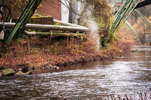 District heating pipeline in front of old industrial buildings on the banks of the Wupper,