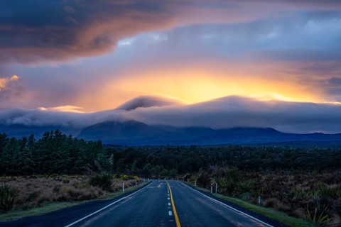 Mount Ngauruhoe in the morning at sunrise with glowing clouds, road SH 47. Tongariro National Park,