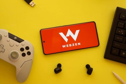 Dhaka, Bangladesh- 22 Mar 2025: Smartphone with Webzen logo, game controller, and earbuds on a