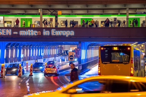 The main train station in Essen, blue illuminated underpass, bus station, am Europaplatz, train on
