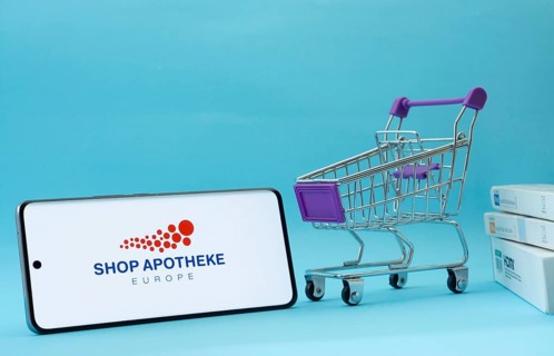 Dhaka, Bangladesh- 21 Nov 2025: Smartphone with Shop Apotheke logo next to a small shopping cart