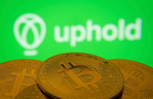 Dhaka, Bangladesh- 19 Sep 2025: Close-up of Bitcoin coins with the Uphold logo visible on a screen