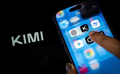 In this photo illustration, a person uses the Kimi AI chatbot on a smartphone while the KIMI logo