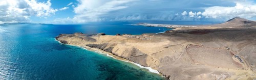 Coast with Playa Caleta del Congrio beach and blue sea, arid landscape of Los Ajaches Natural Park,